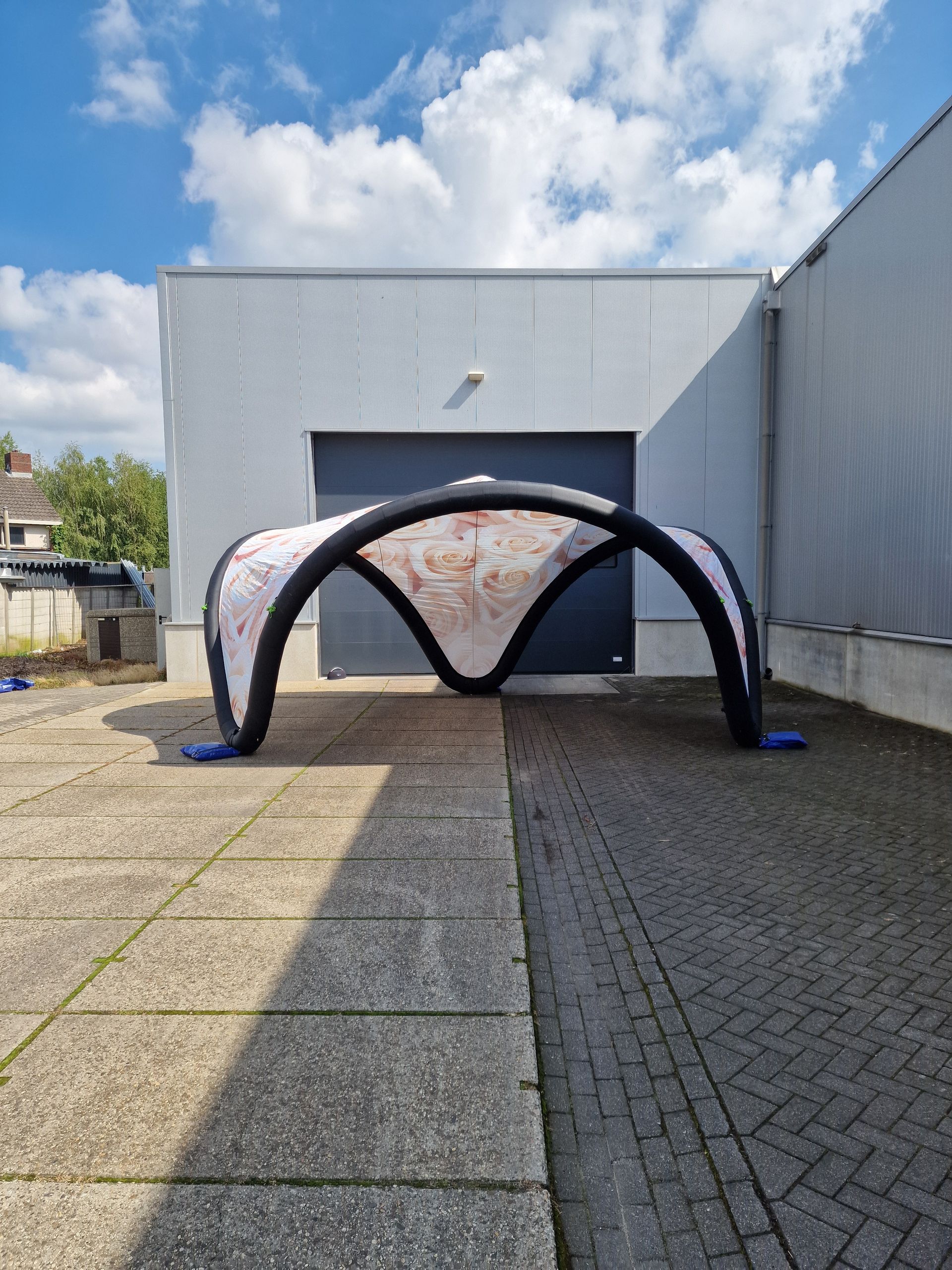 Een grote opblaasbare tent staat voor een gebouw.