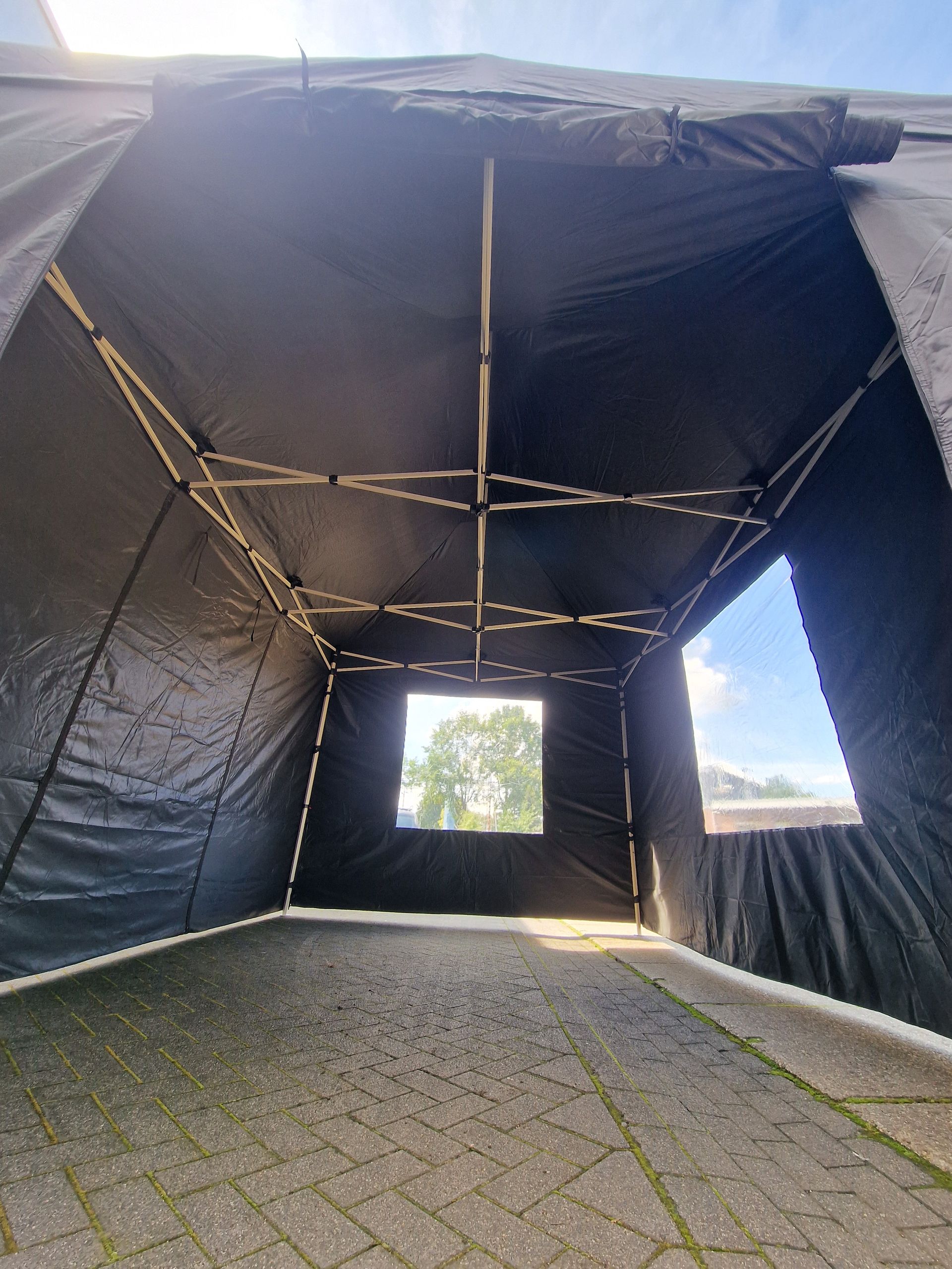 De binnenkant van een zwarte tent met een raam