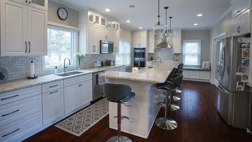 A kitchen with white cabinets , granite counter tops , stainless steel appliances and hardwood floors.