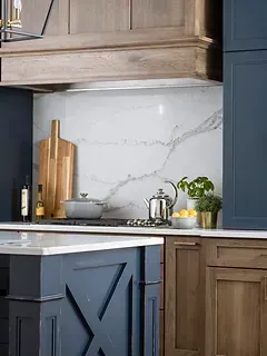 A kitchen with blue cabinets and wooden cabinets and a stove top oven.