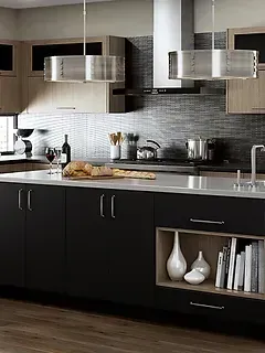 A kitchen with black cabinets , stainless steel appliances , a sink and a bottle of wine on the counter.