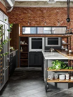 A kitchen with a brick wall and stainless steel appliances.