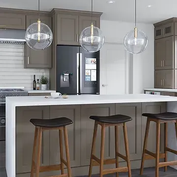 A kitchen with a large island , stools , a refrigerator and a stove.