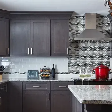 A kitchen with dark wood cabinets and a granite counter top