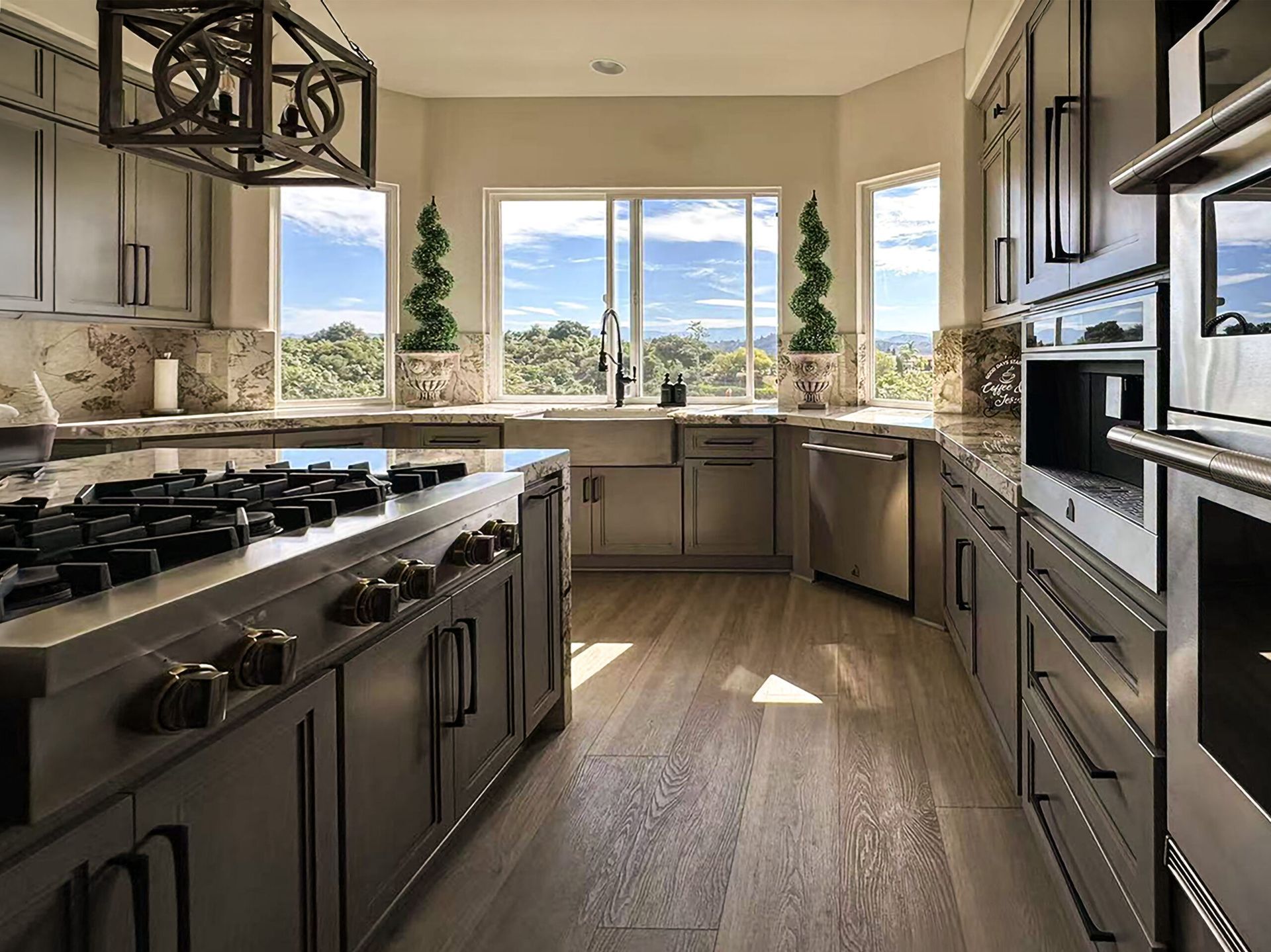 A kitchen with blue cabinets , a refrigerator , a stove , and a wine rack.