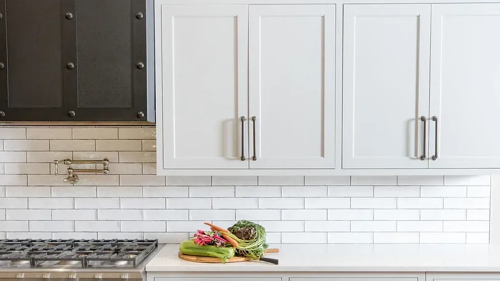 A kitchen with white cabinets and a stove top oven.