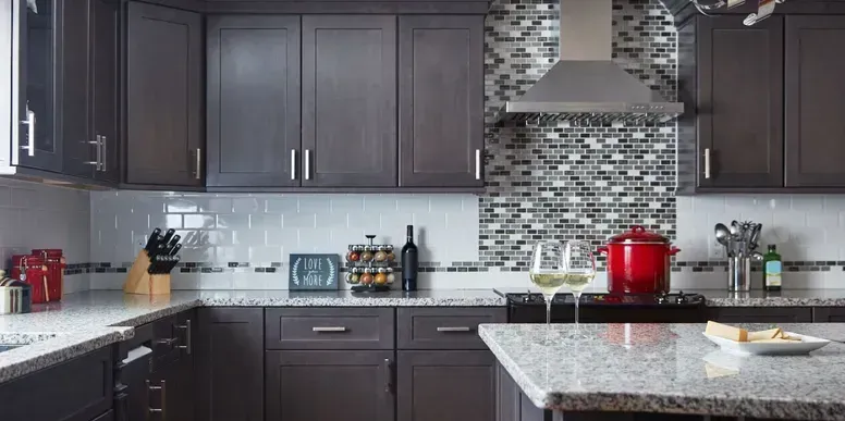 A kitchen with dark wood cabinets and granite counter tops.
