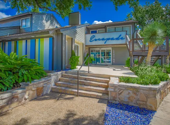Modern building entrance with blue trim, stairs, stone planters, and the sign “Eucalyptus”