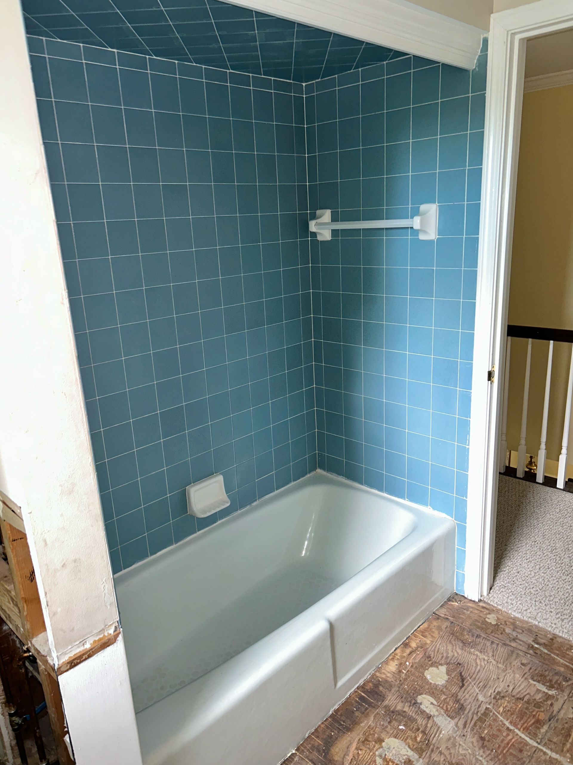 In this picture you can see a bathtub with outdated, blue tiles. This backsplash could be easily transformed into something more modern with a bathtub refinishing job. 