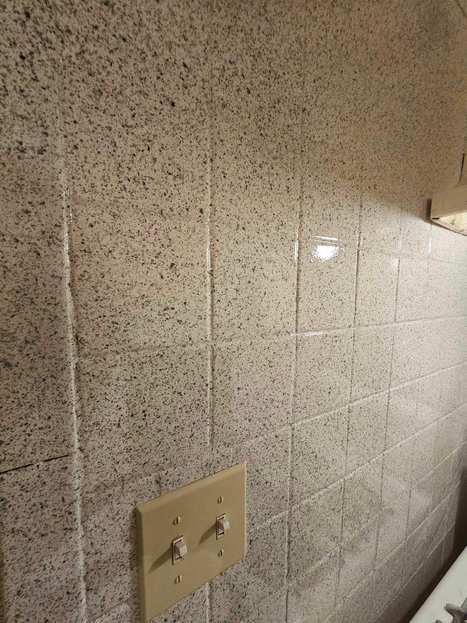 Picture of the backsplash of a kitchen. 
The material used in this case are tiles that have a granite like finishing. which gives it a modern look. 