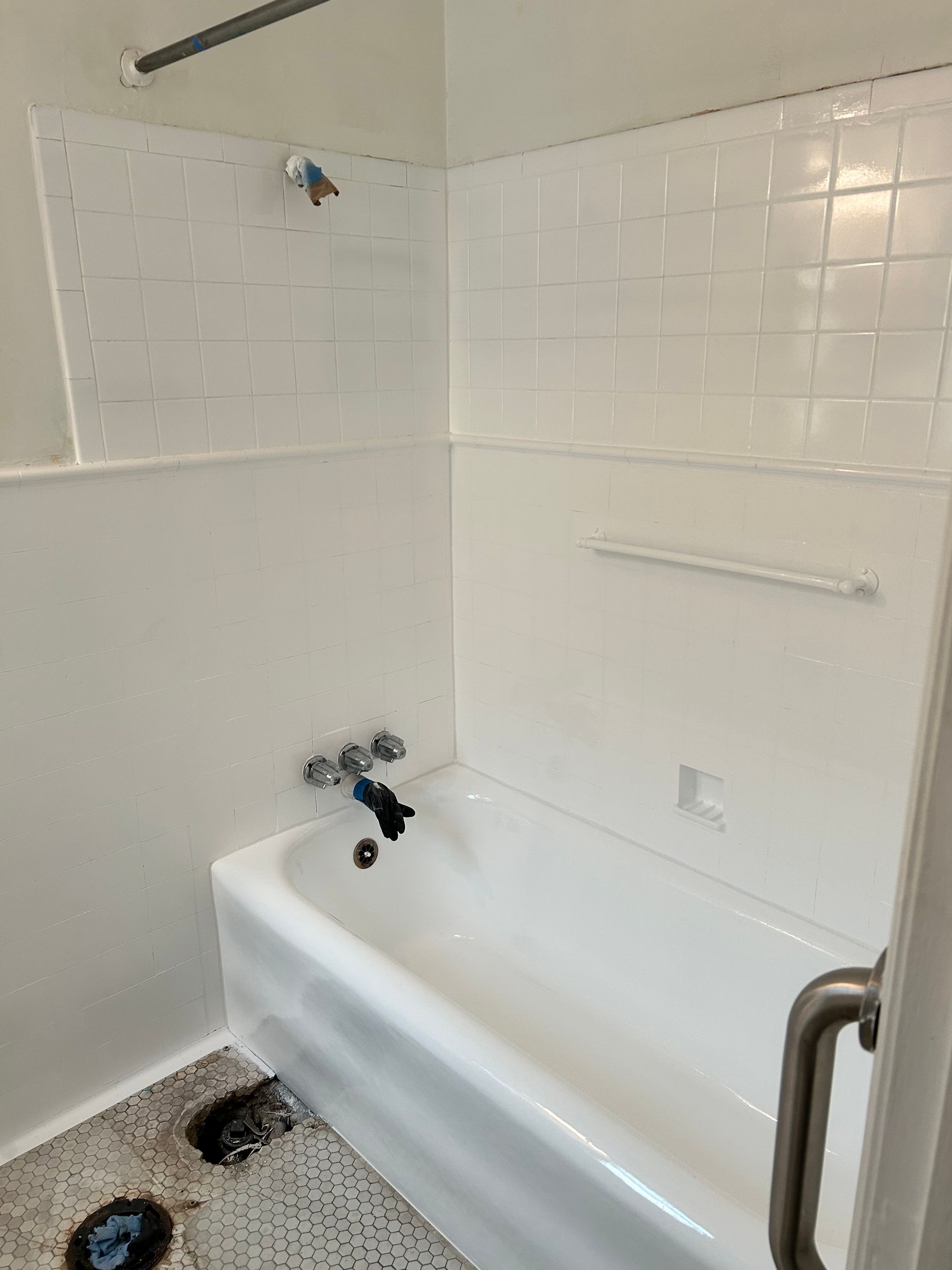 Image of a bathtub that has been refinished white. You can see to the left the same bathtub before it was refinished. The bath tile has also been refinished. 