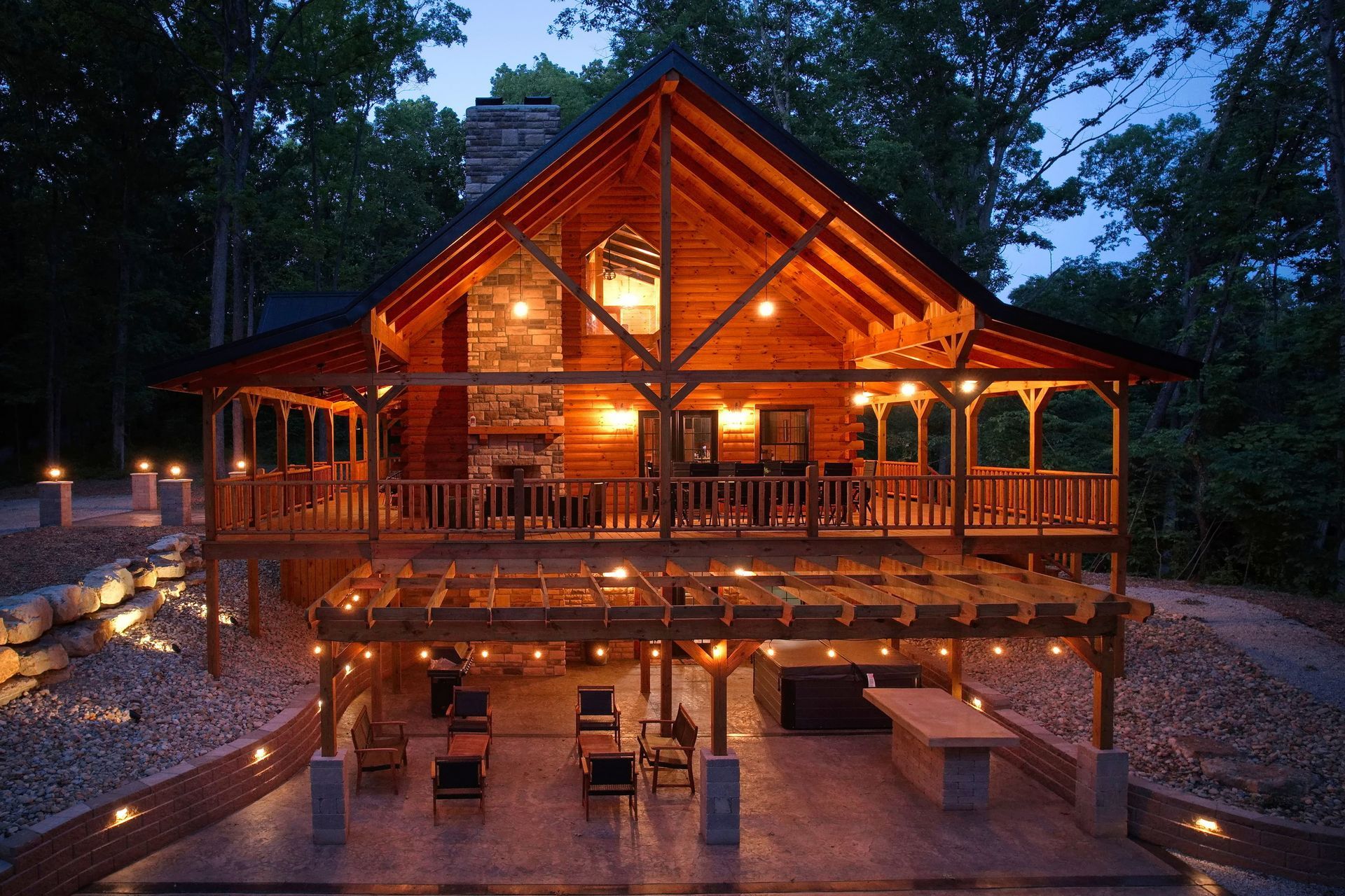 A large log cabin is lit up at night