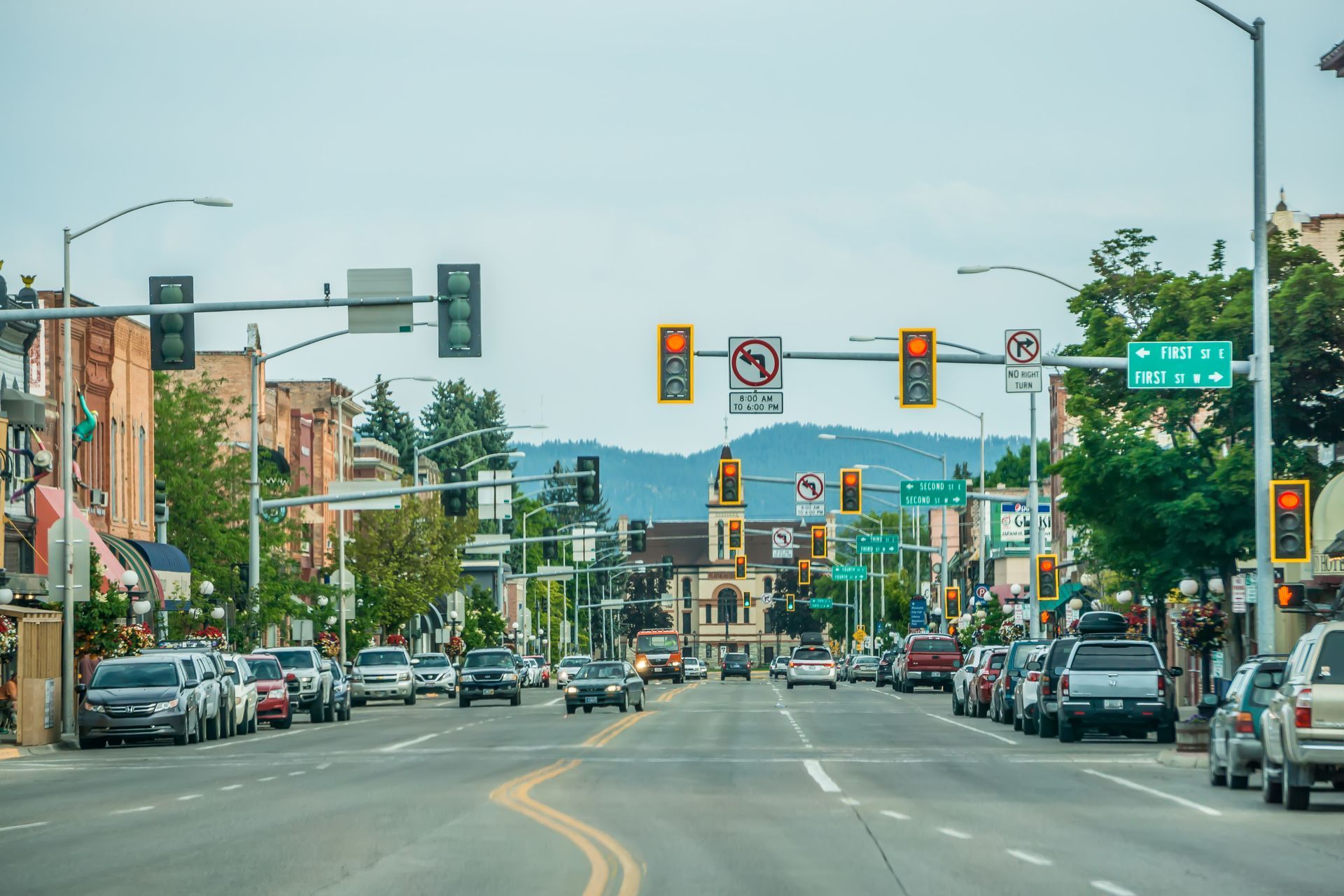 Street scene with cars, buildings, and traffic lights; mountain backdrop.