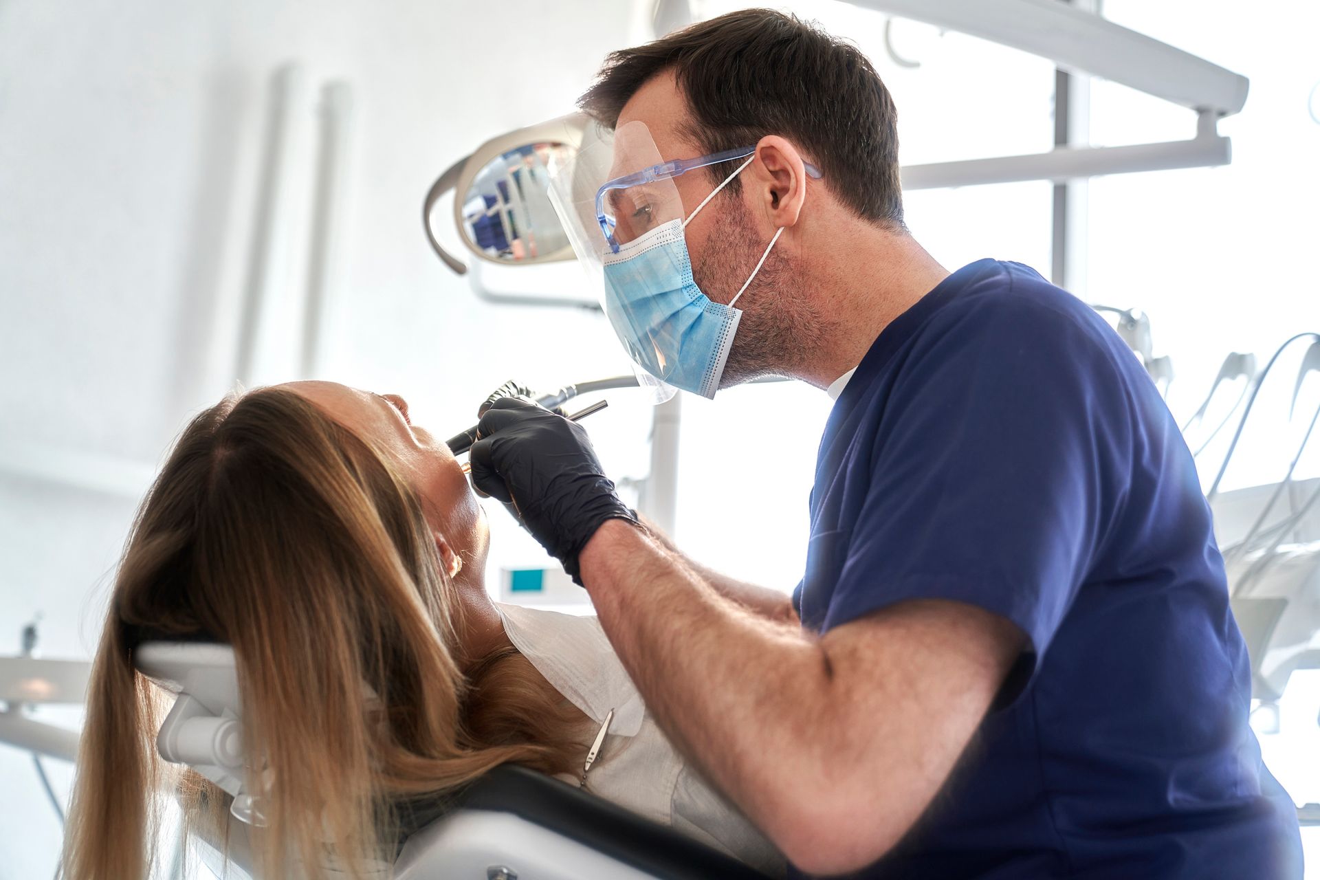 Un dentista sta esaminando i denti di una donna in uno studio dentistico.