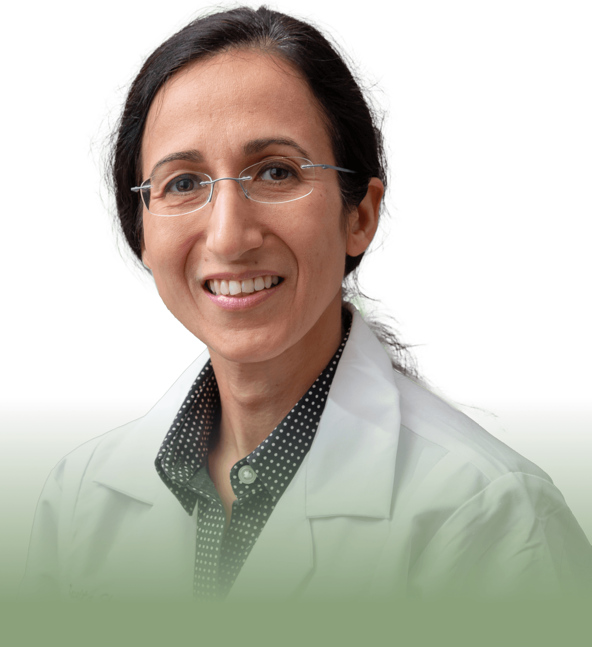 A woman wearing glasses and a lab coat smiles for the camera