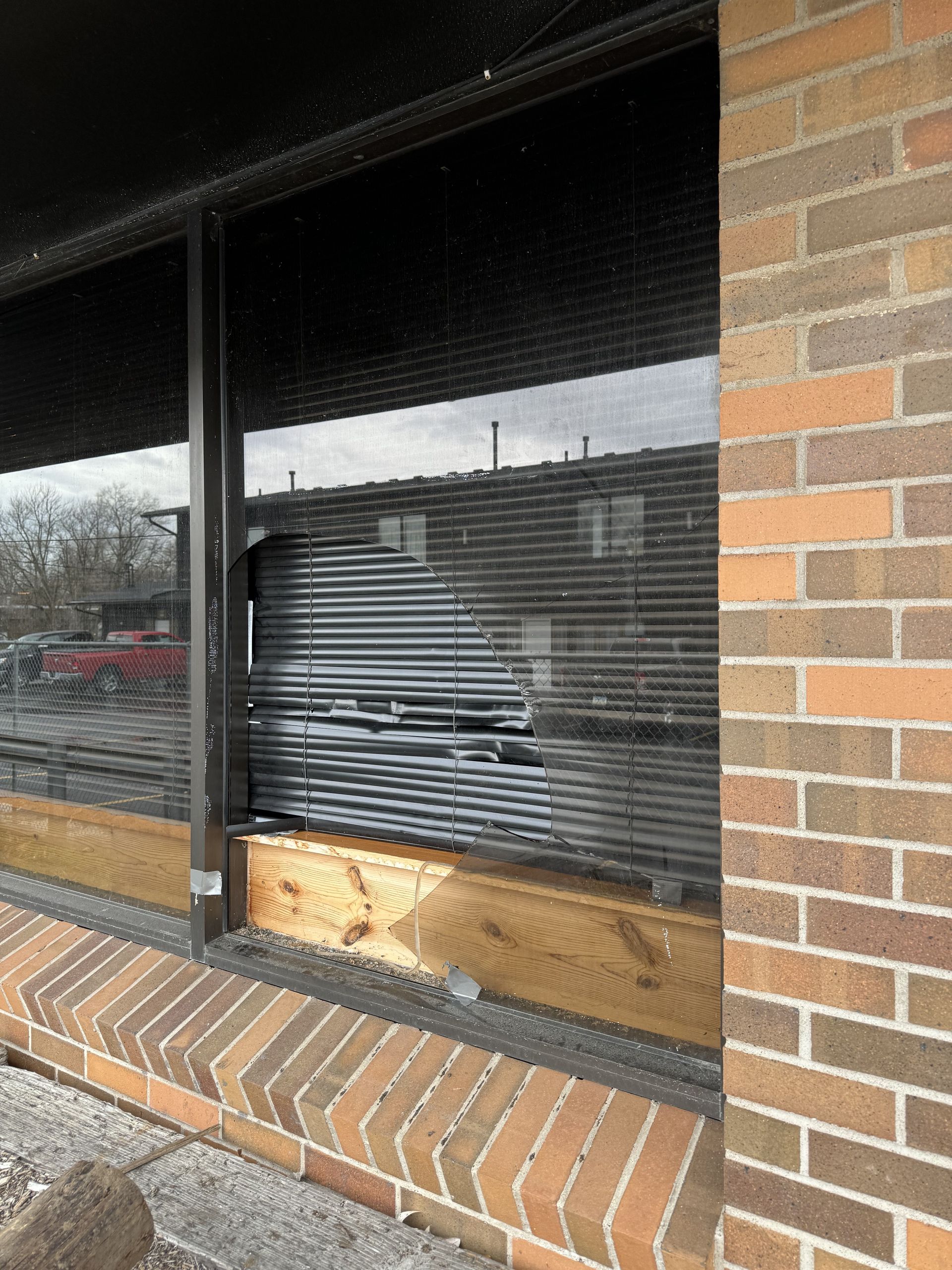 A brick building with a window with blinds on it