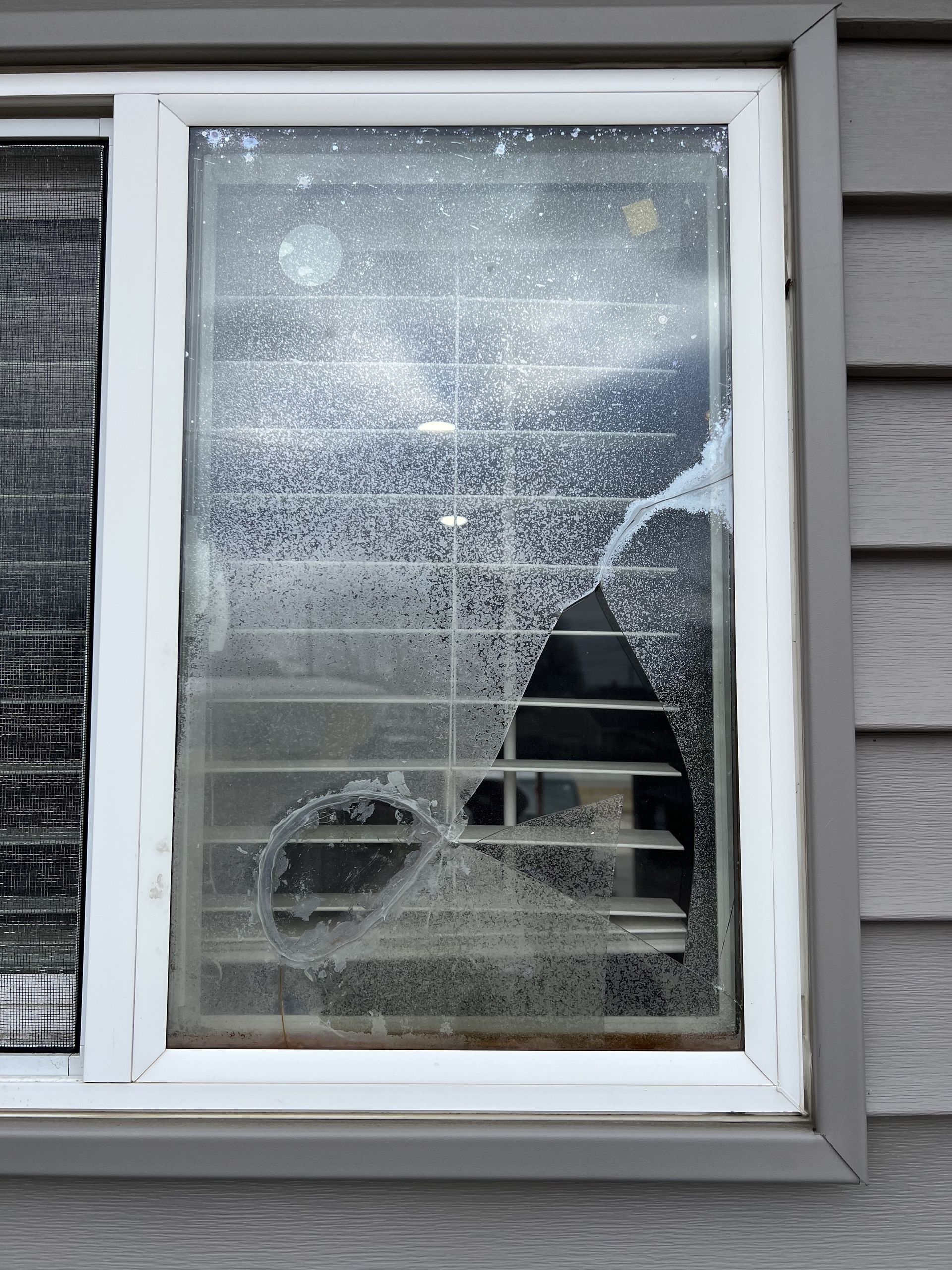 A broken window on the side of a house.