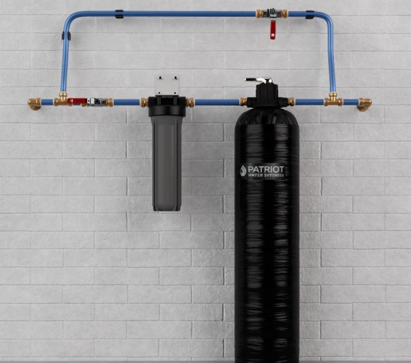 A water filtration system with a black tank and four filters mounted under a kitchen sink.