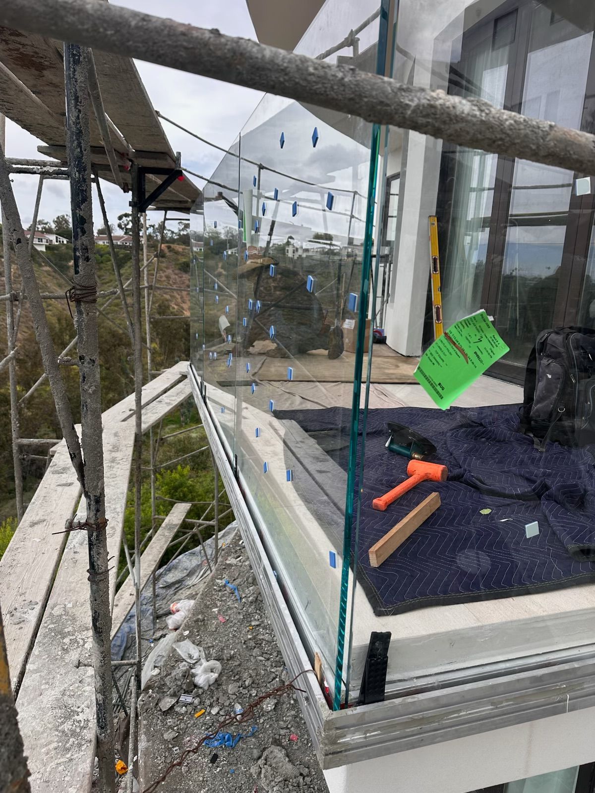 A person wearing yellow work gloves uses a screwdriver to install a window frame into a roof.