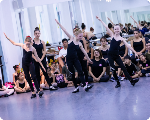 A group of young girls are dancing in a dance studio