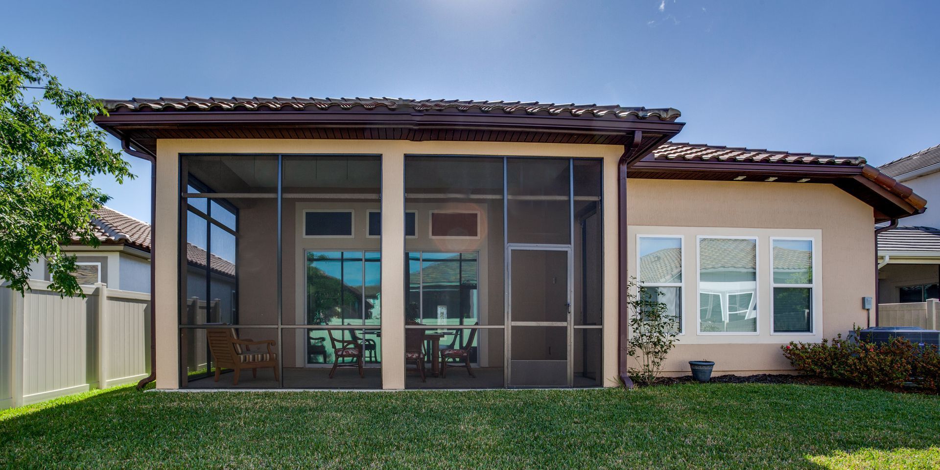 A house with a screened in porch in the backyard