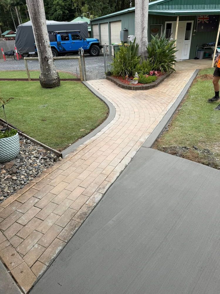 Brick Pathway Curving to a Garden Bed Near a House and Lawn — JDC Concreting in Lismore, NSW