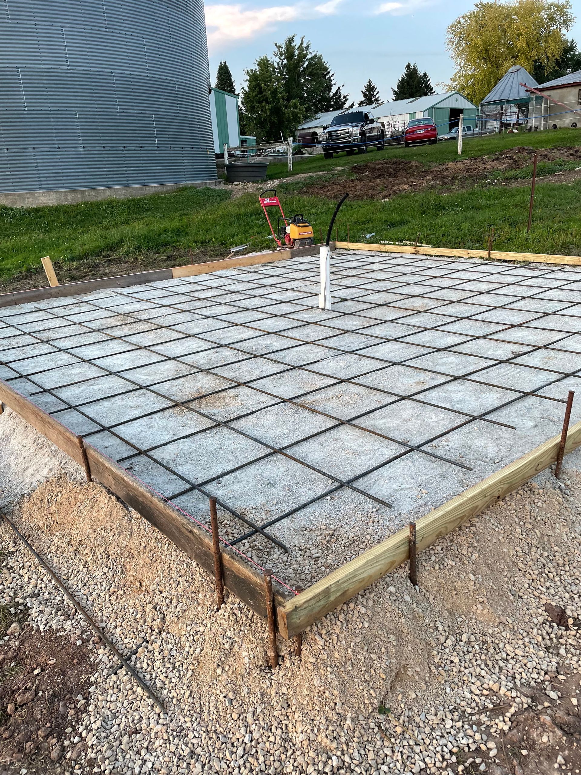 A concrete foundation is being built in a field.