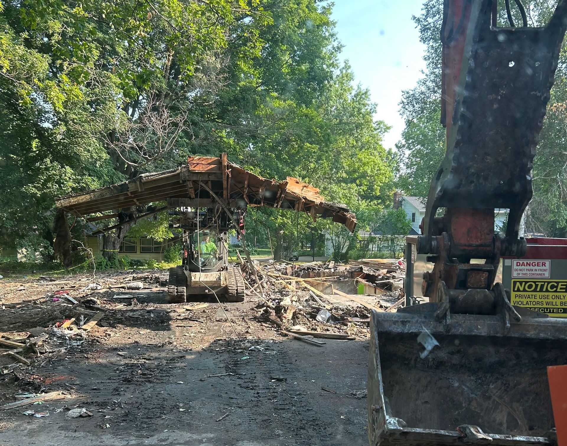 A construction site with a bucket that says ' demolition ' on it