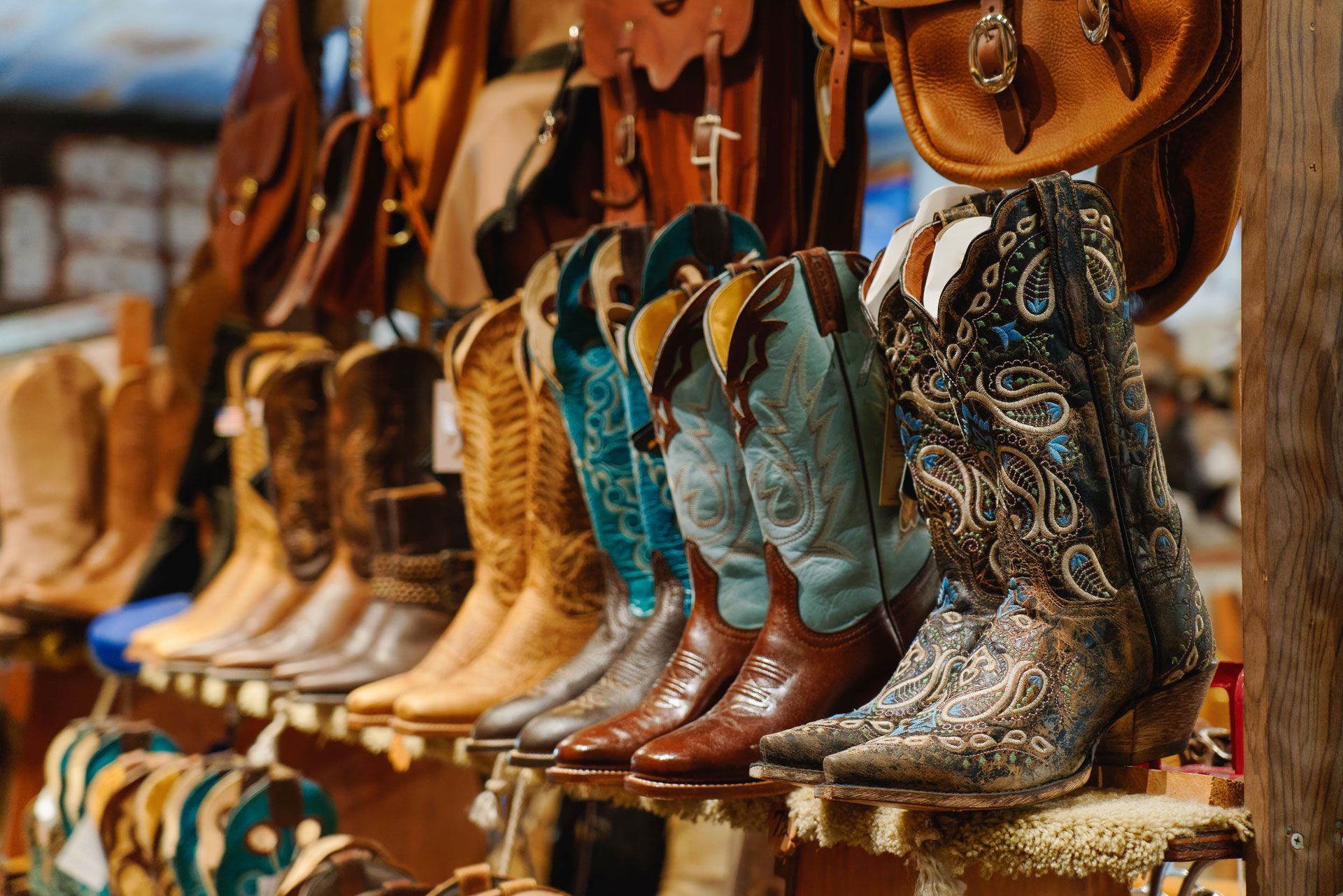 Cowboy boots of varying colors on display.