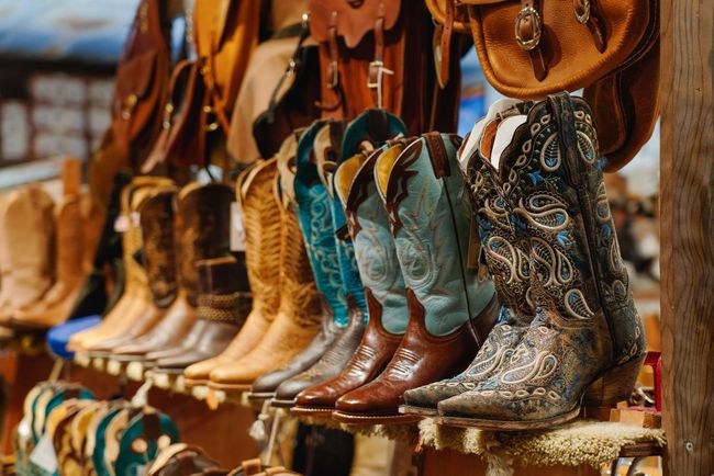 Cowboy boots of varying colors on display.