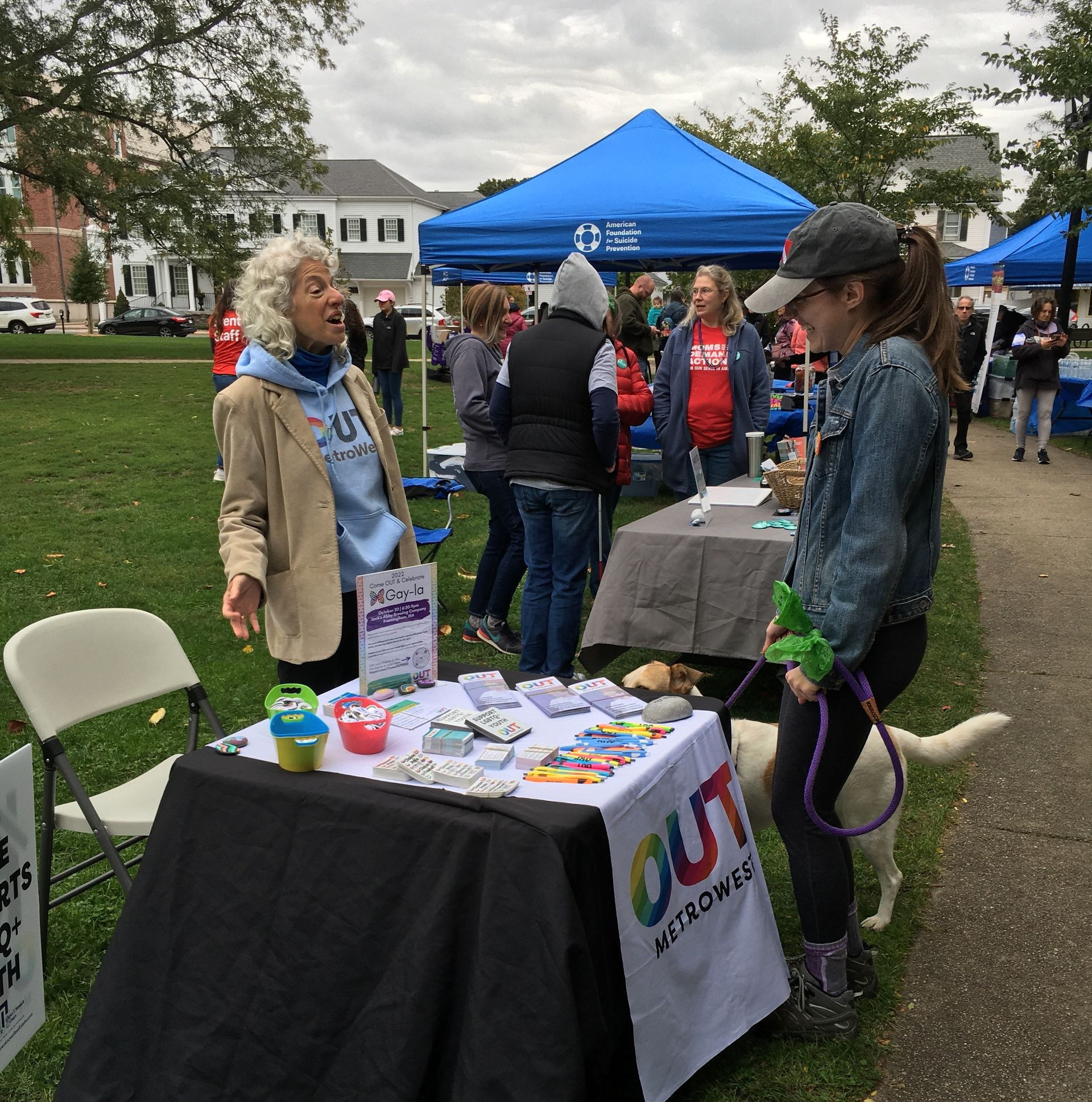 People at an outdoor event with a table displaying 