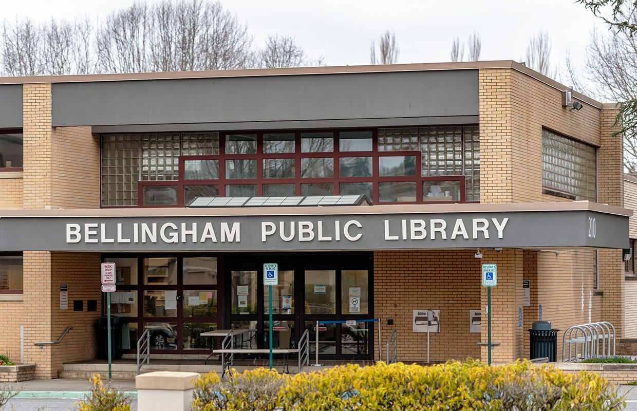 Medway Public Library in winter, snow-covered building with sign and bare trees.
