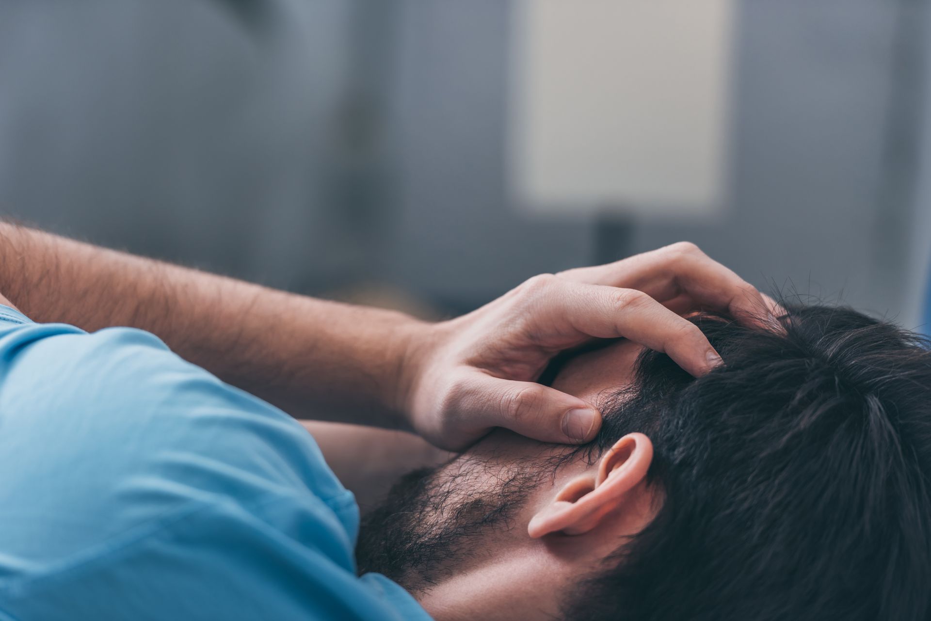 Selectieve focus van een rouwende man die met zijn handen zijn gezicht bedekkend ligt te huilen op bed.