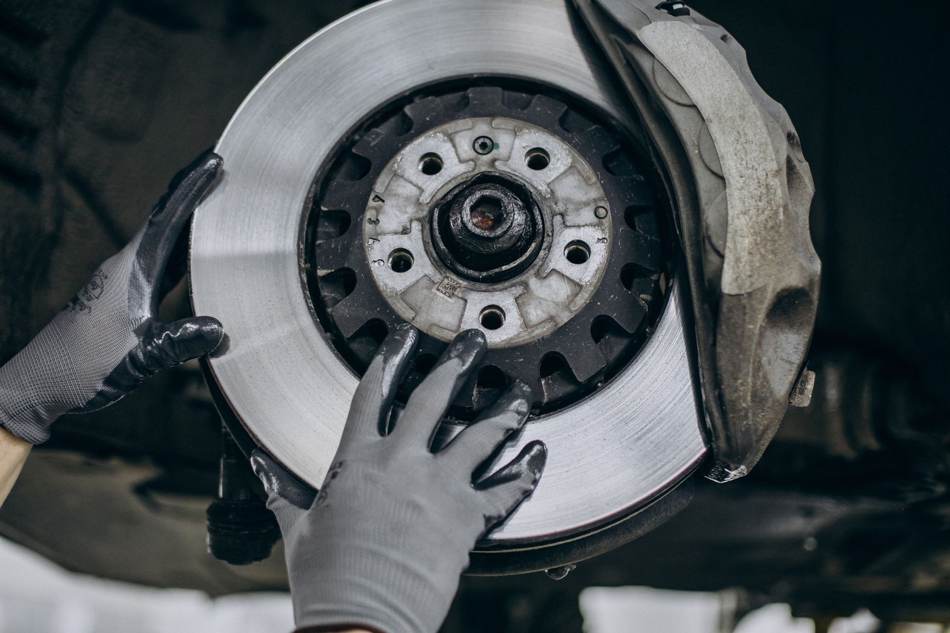 A person is fixing a brake disc on a car.