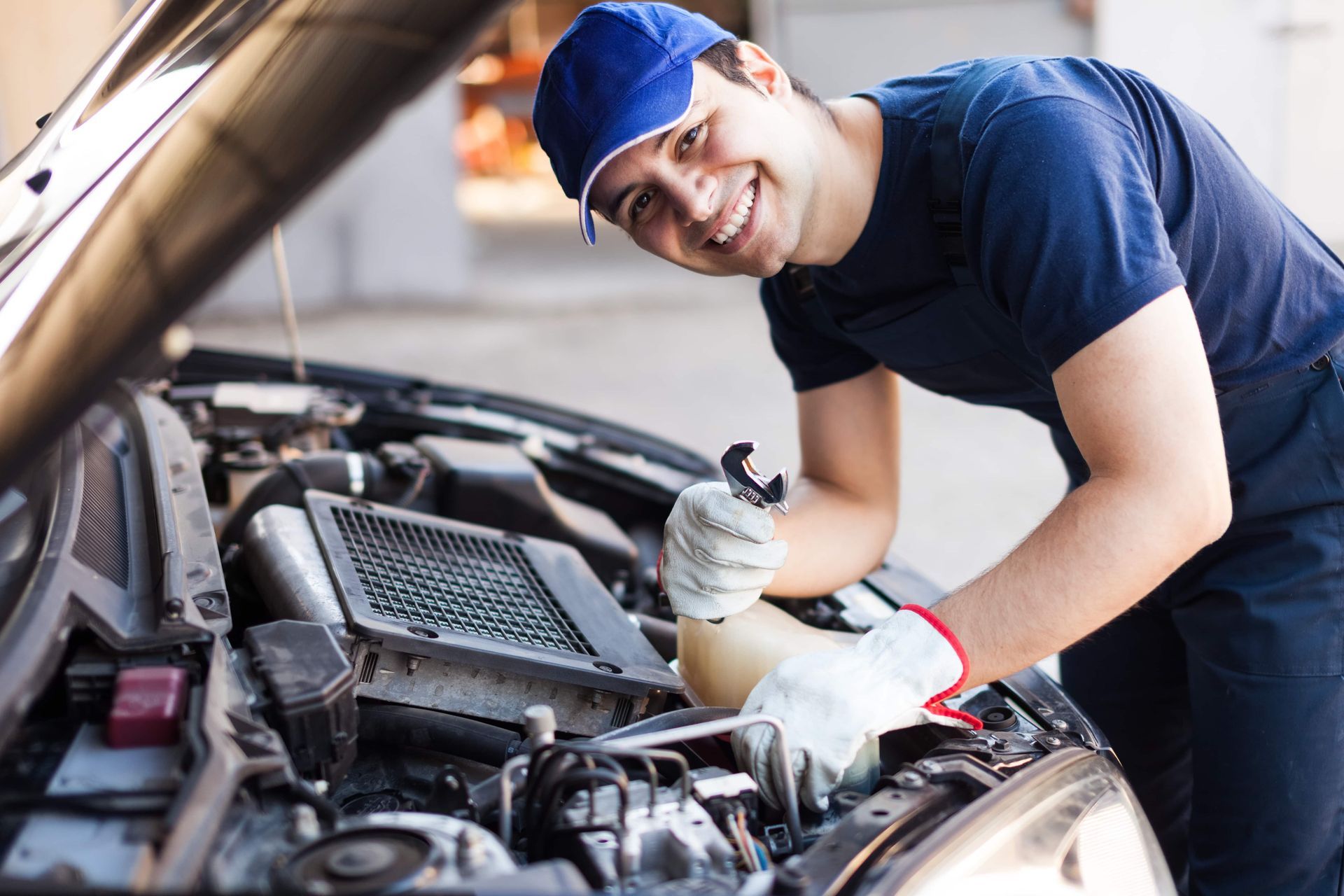 A man is working on the engine of a car.