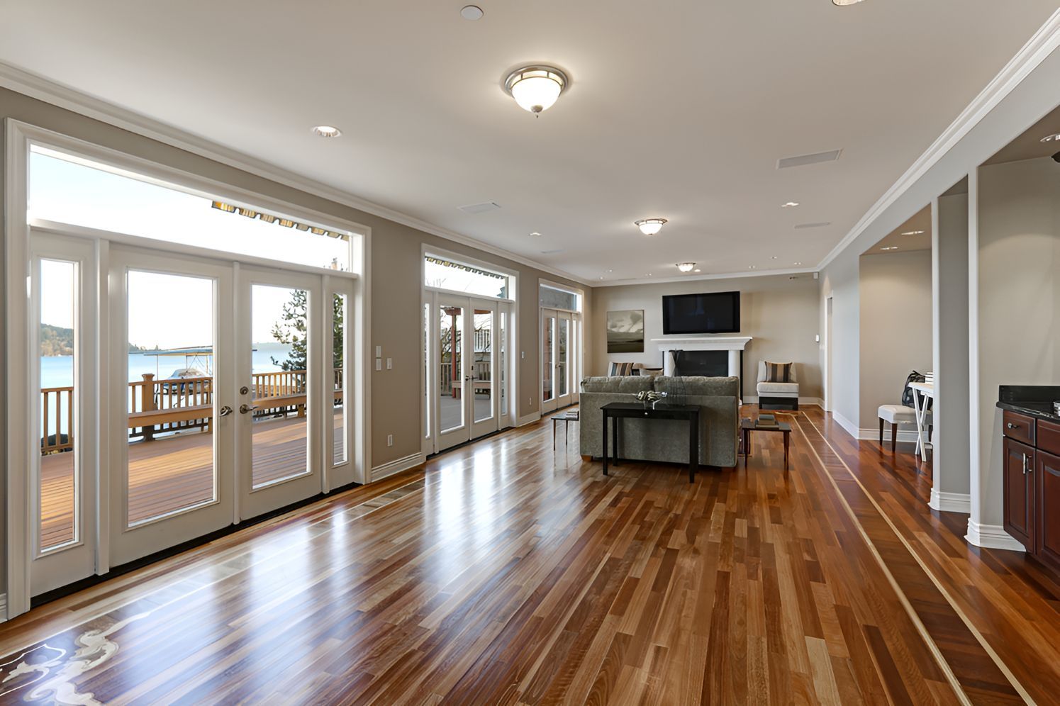 A large living room with lots of big glass doors, a couch and a TV on the wall — Twin Cities Glass In Albury, NSW