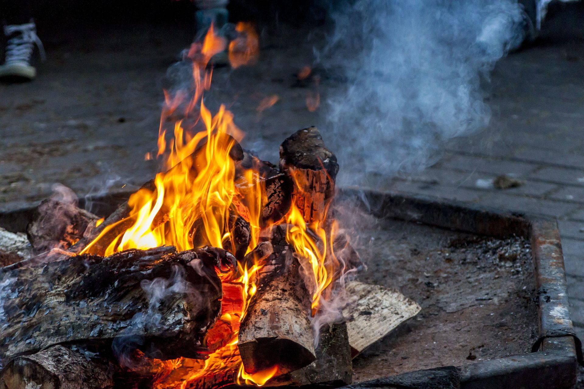 A close up of a fire pit with smoke coming out of it.