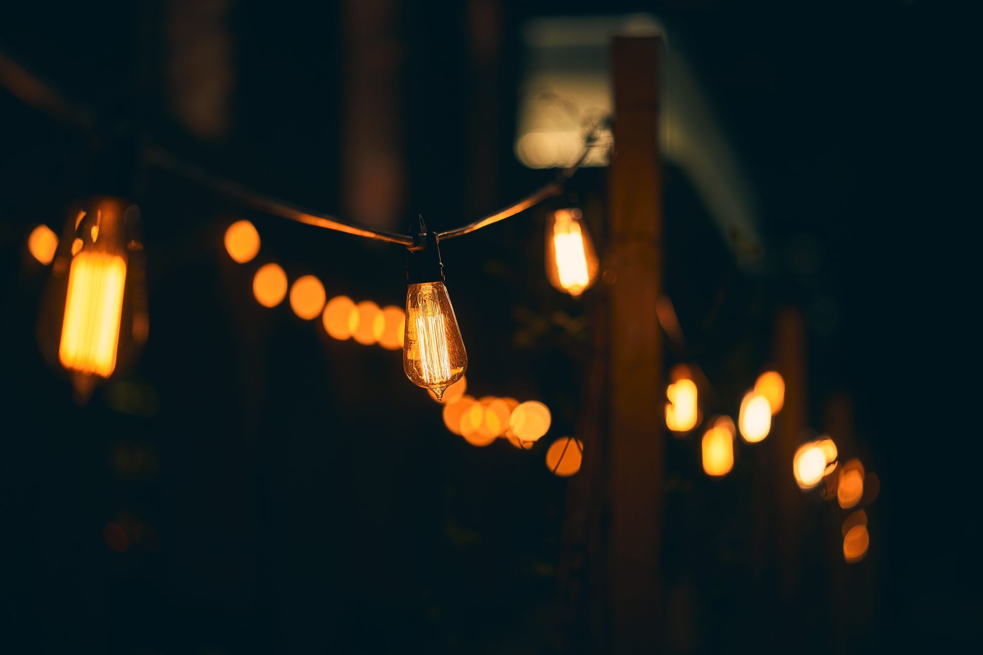 A string of lights hanging from a pole at night.