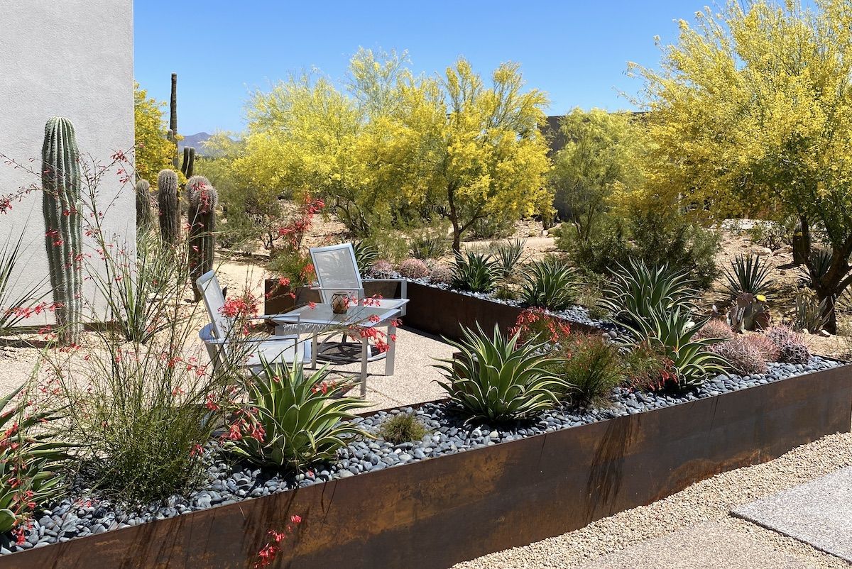 A patio area with a table and chairs in the desert.