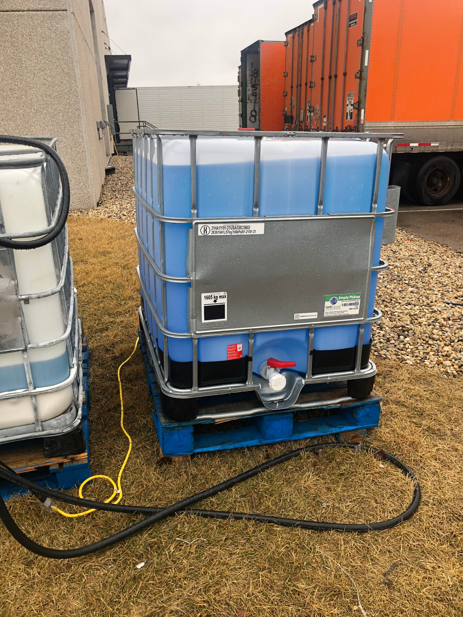 A large container of blue liquid is sitting on a pallet.