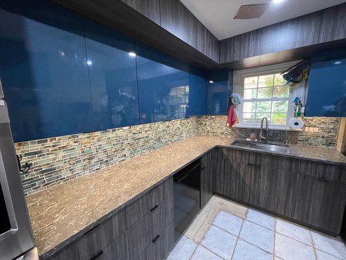 A kitchen with blue cabinets and granite counter tops.
