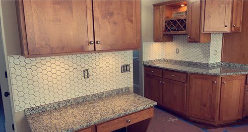 A kitchen with wooden cabinets and granite counter tops.