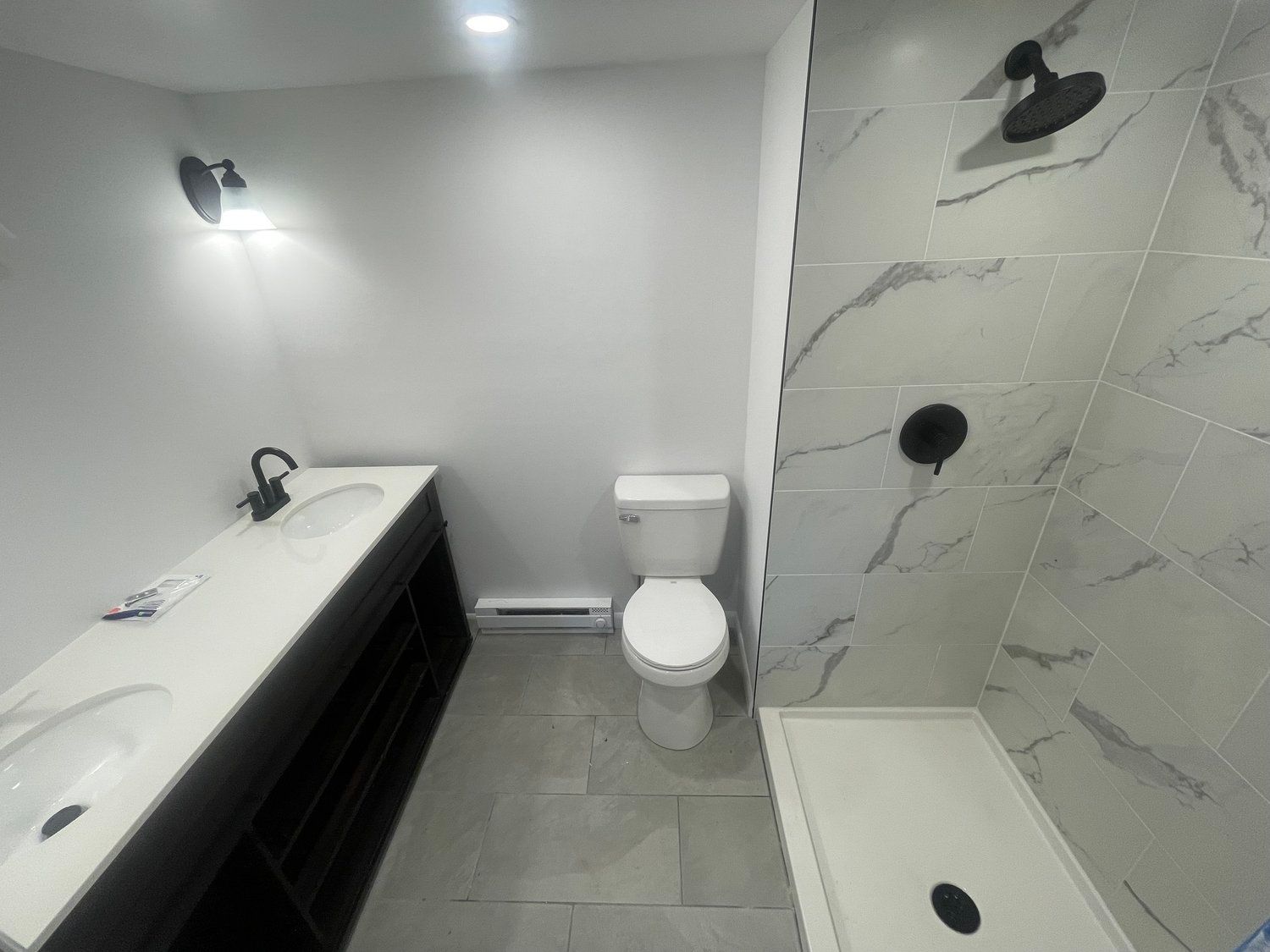A bathroom with a toilet , sink and shower.