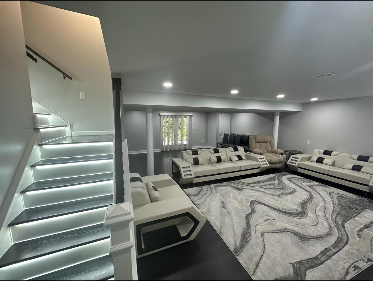 A living room with a rug , couch , and stairs