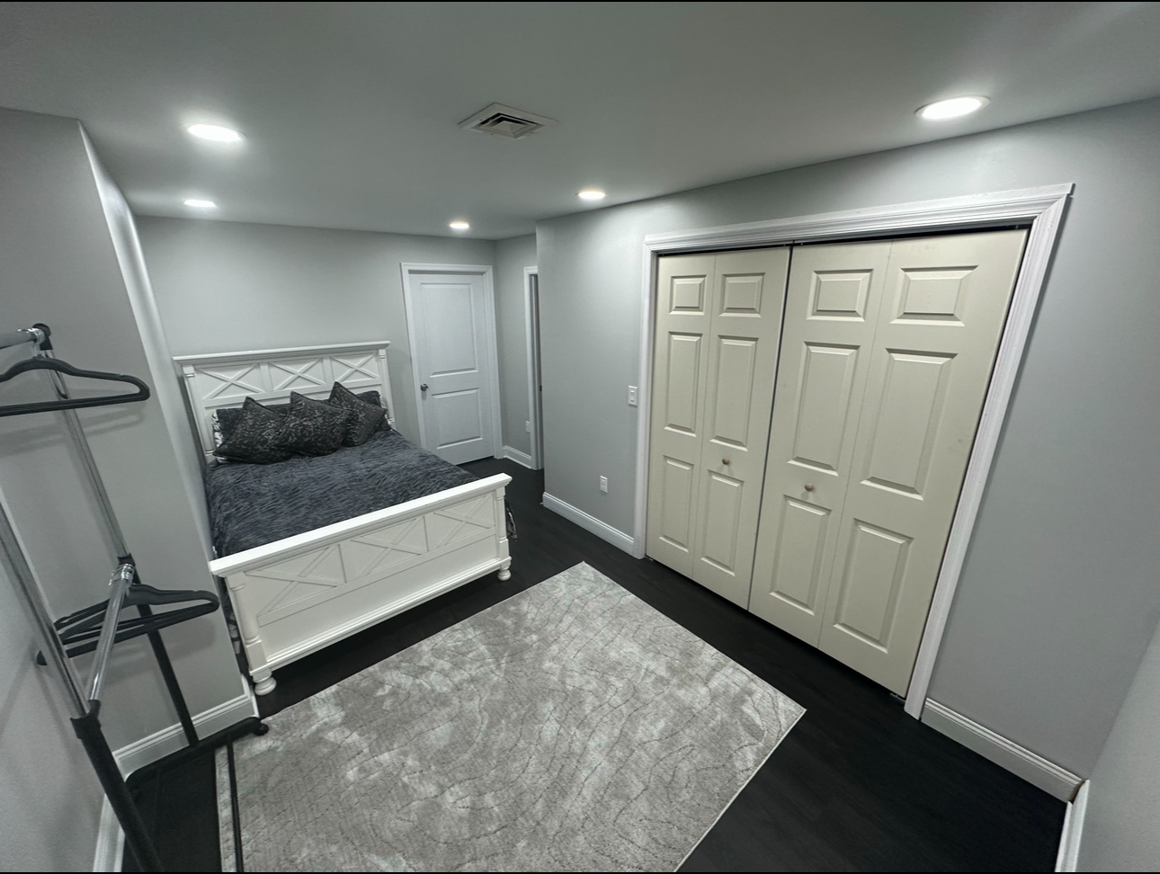 A bedroom with a bed , closet , and rug.