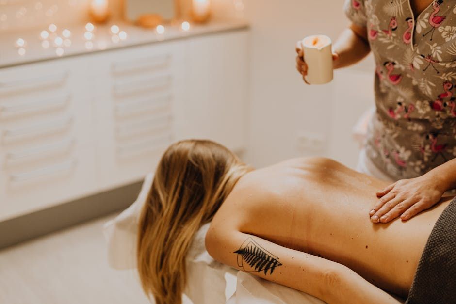 Spa therapist applying a treatment to a woman lying face down on a massage table