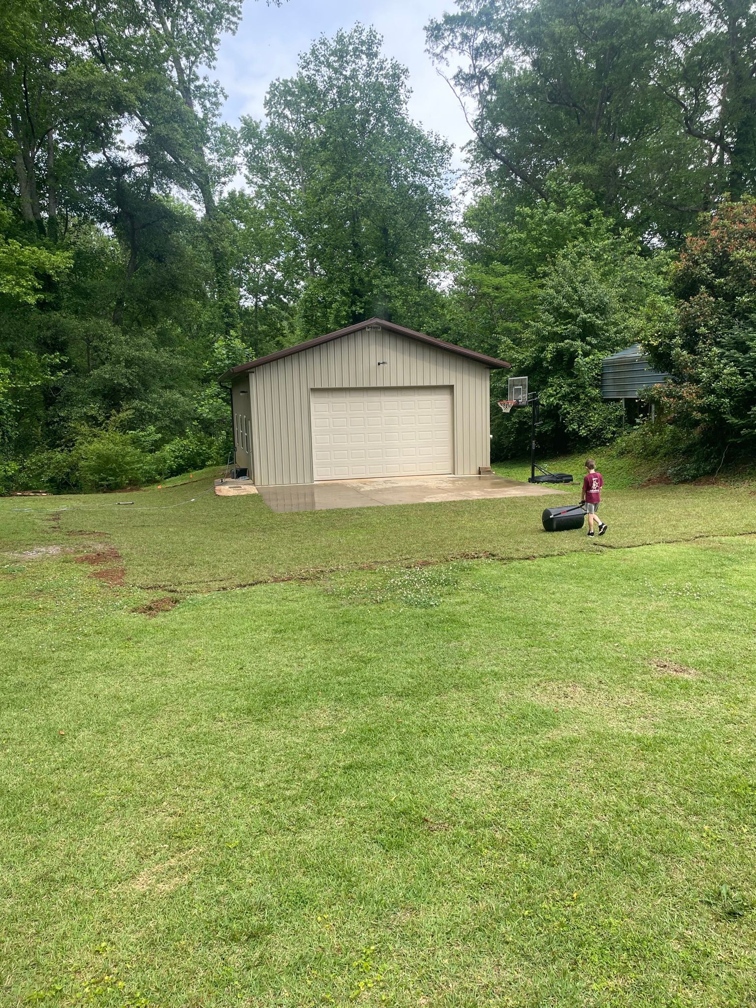 A garage is sitting in the middle of a lush green field.