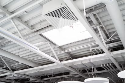 White industrial ceiling with beams, vent, and lights.