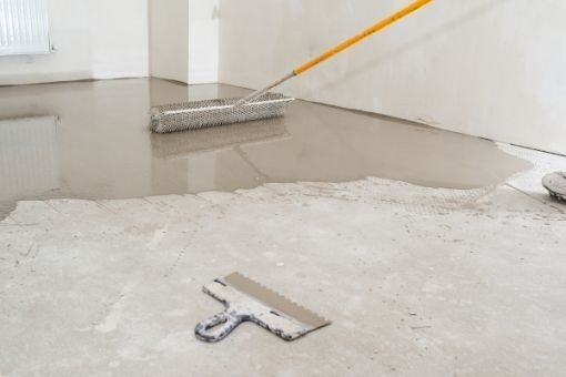 screed floor levelling compound being spread out
