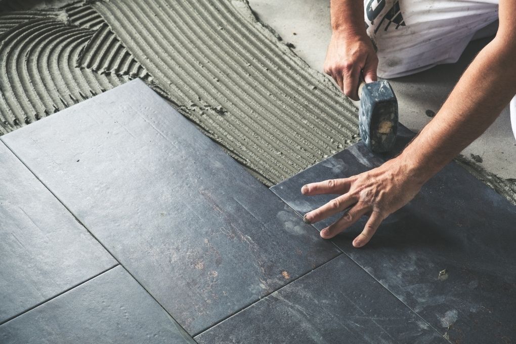 dark ceramic floor tiles being installed